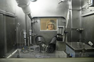 A scientist works in a glove box