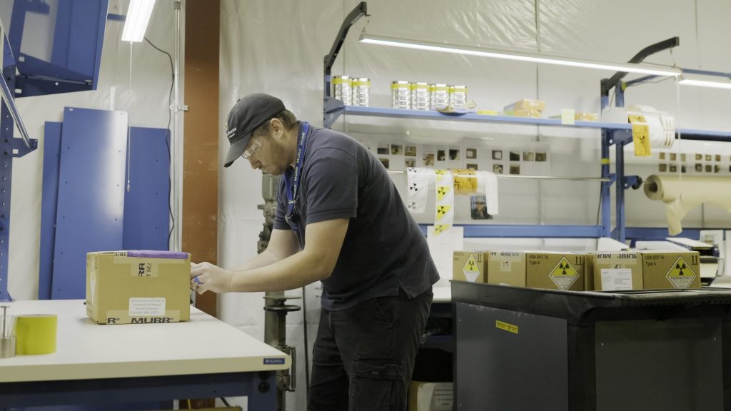 A shipping tech prepares a box for shipping