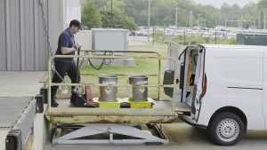 A shipping tech moves a shipment into a van