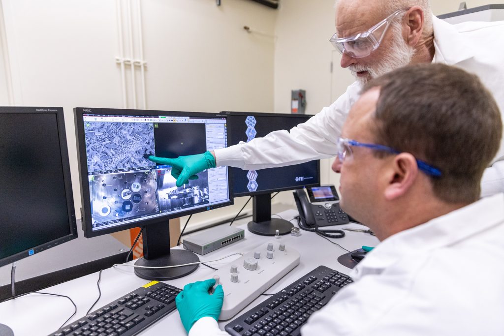 two scientists review images on a computer screen