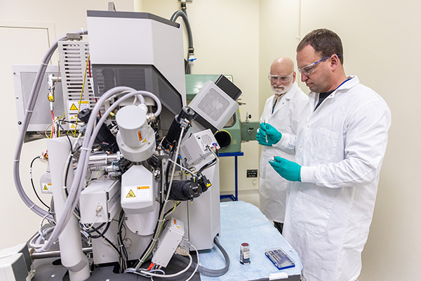 two scientists prepare a sample for the scanning electron microscope