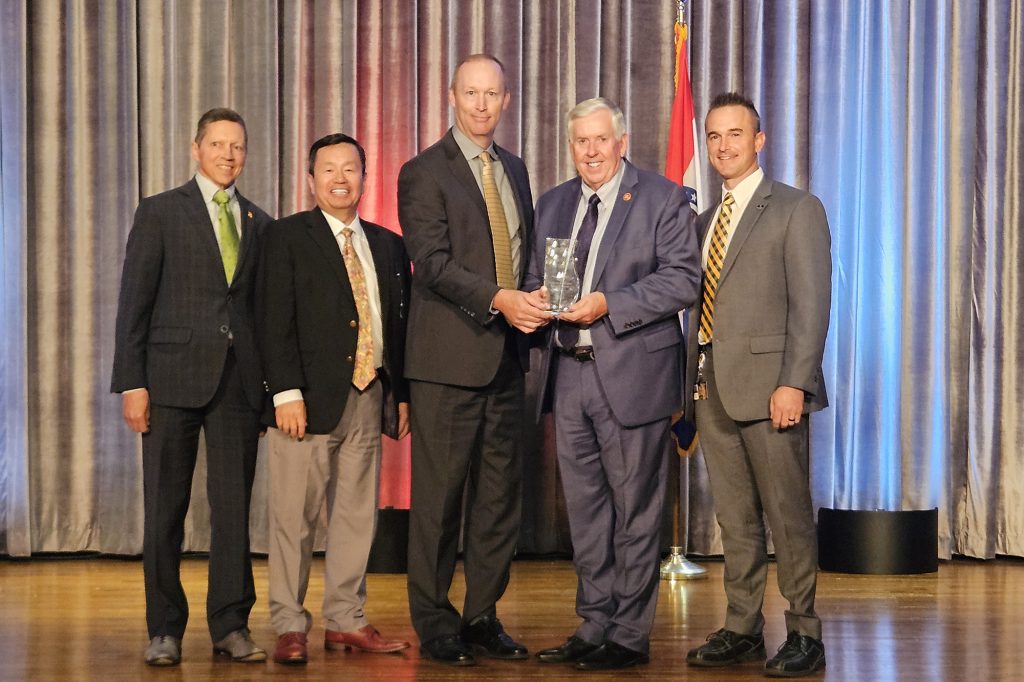 Governor Mike Parson presents the Hawthorn Foundation Project of the Year Award to UM System President Mun Choi and other university leaders.